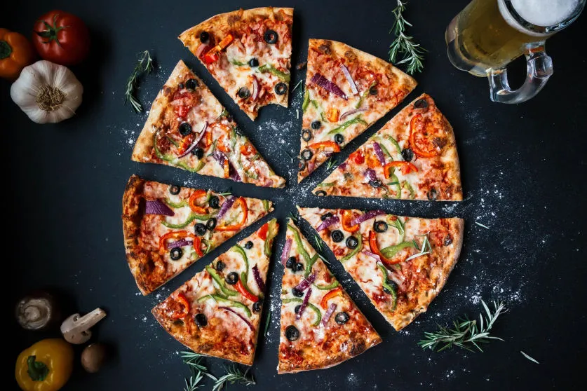 Szeletekre vágott pizza az asztalon
