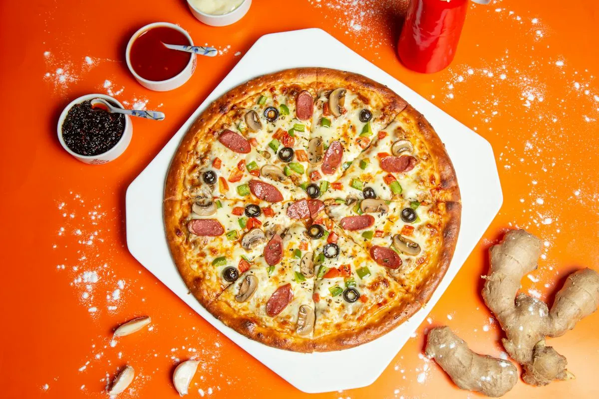 Kerek pizza tálalva élénk háttéren